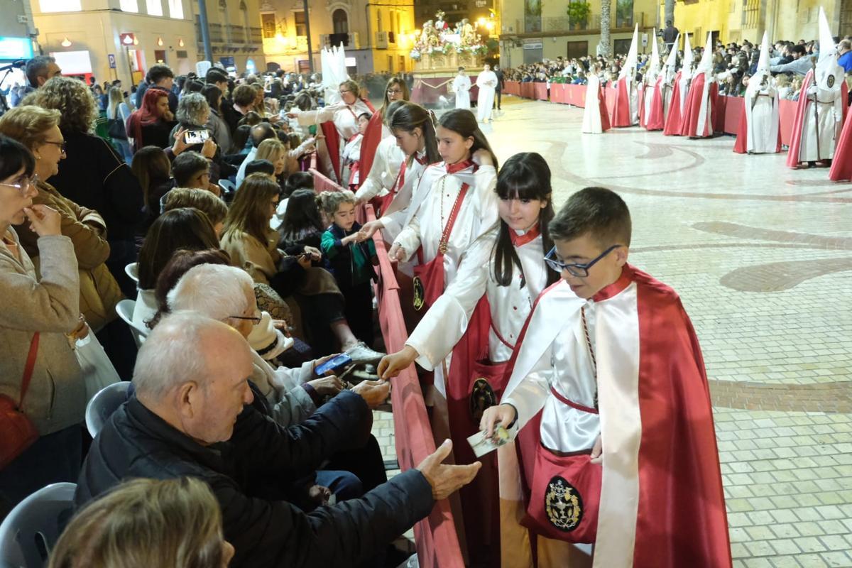 Niños repartiendo caramelos en el paso de &quot;El Gallo&quot; por la plaça de Baix en Elche.