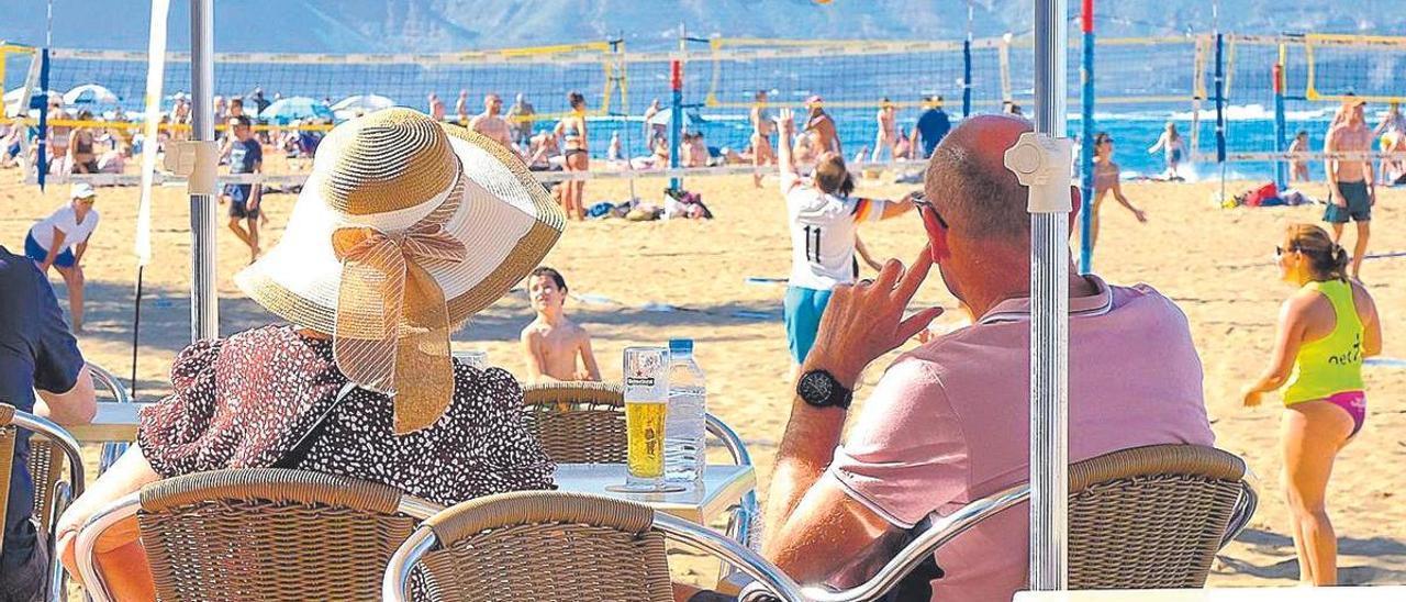 Turistas en el Paseo de Las Canteras, en Las Palmas de Gran Canaria, contemplan la playa.