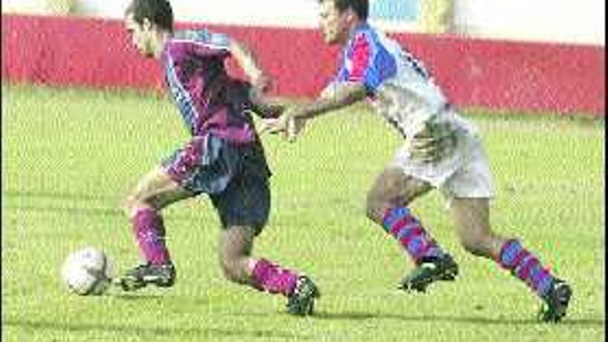 Juanma, a la izquierda, controla el balón durante un partido del Navarro.