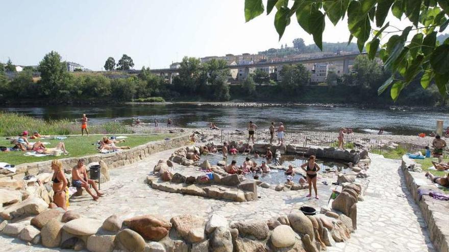A pesar de los más de 40º en Ourense, los bañistas no renunciaron a las termas.  // Jesús Regal