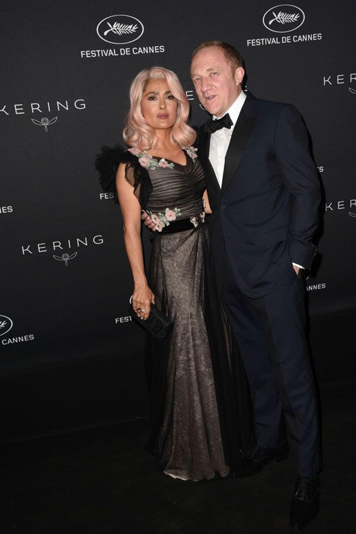 Salma Hayek con el pelo rosa y vestido de Gucci junto a su marido