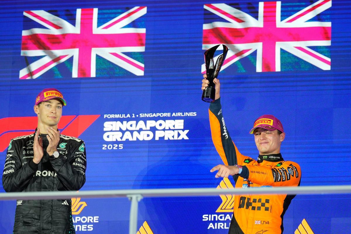 McLaren driver Lando Norris of Britain, right, celebrates after wining the third position, as first position winner Mercedes driver George Russell of Britain, left applauds during the Singapore Formula One Grand Prix at the Marina Bay Street Circuit in Singapore, Sunday, Oct. 5, 2025. (AP Photo/Vincent Thian)