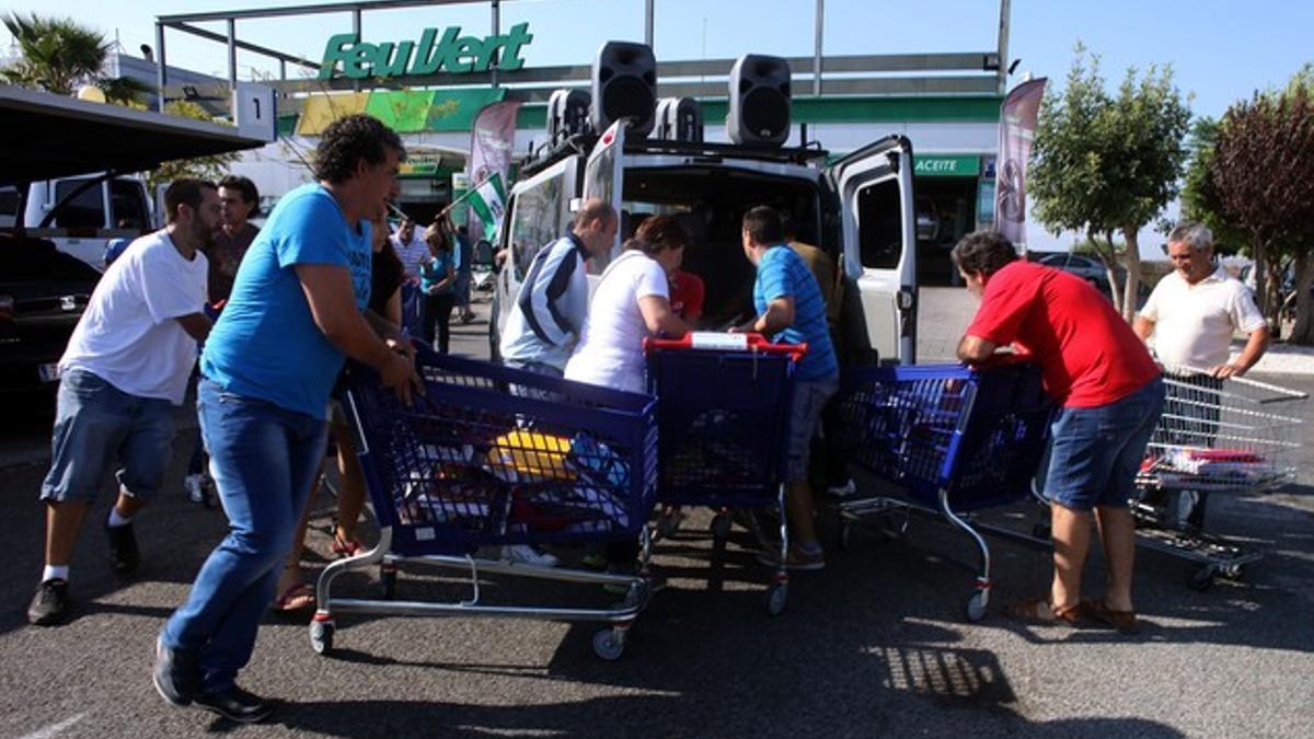 Miembros del SAT se llevan carros con material escolar, este viernes en un centro comercial de Sevilla.