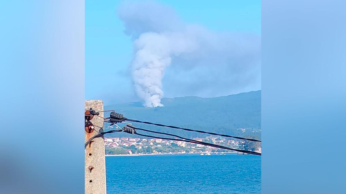 La columna de humo del incendio forestal en Pazos de Borbén, vista desde la ría de Vigo.