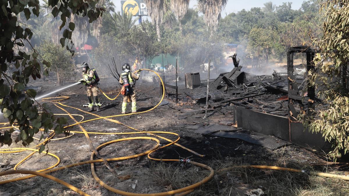 Bomberos sofocando el incendio del lunes en el poblado chabolista de La Fica.
