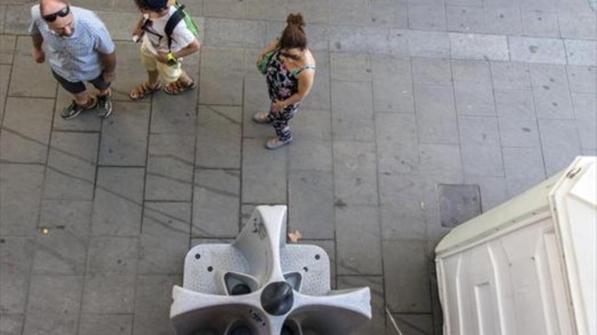 Unos turistas observan el reguero de orines que cae desde los urinarios colocados en la calle de Fusina.