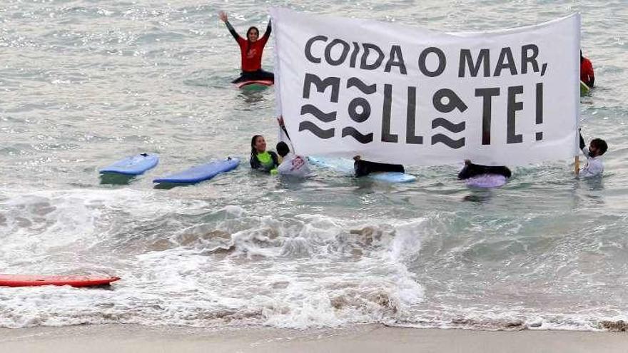 Surfistas coruñeses se concentran dentro de la campaña de sensibilización ambiental &#039;Móllate!&#039; y el montaje de la falla en Riazor.