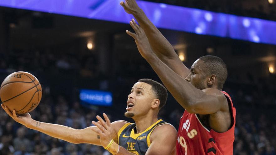 Stephen Curry trata de encestar ante la defensa de Serge Ibaka.