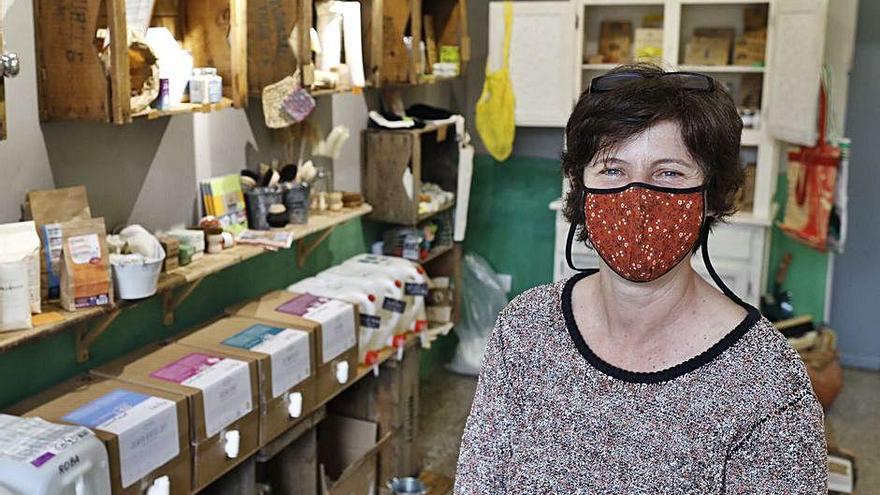 Mercè Juli omplint amb detergent un envàs, extret de la cistella de reutilització de La bio.