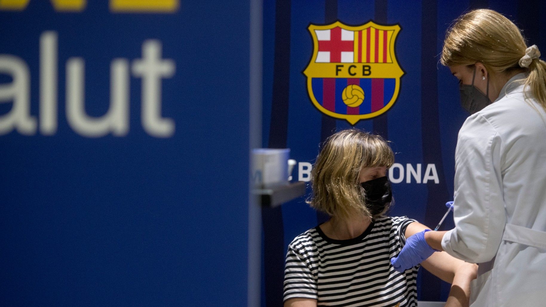 Una mujer se vacuna en el centro de inoculación situado en las instalaciones del Barça, este jueves.