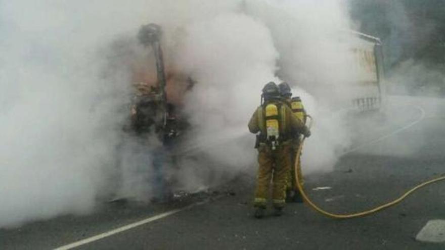 Los bomberos de Ourense atacan con mangueras el incendio que devoró la cabina del camión.  // B. Lorenzo
