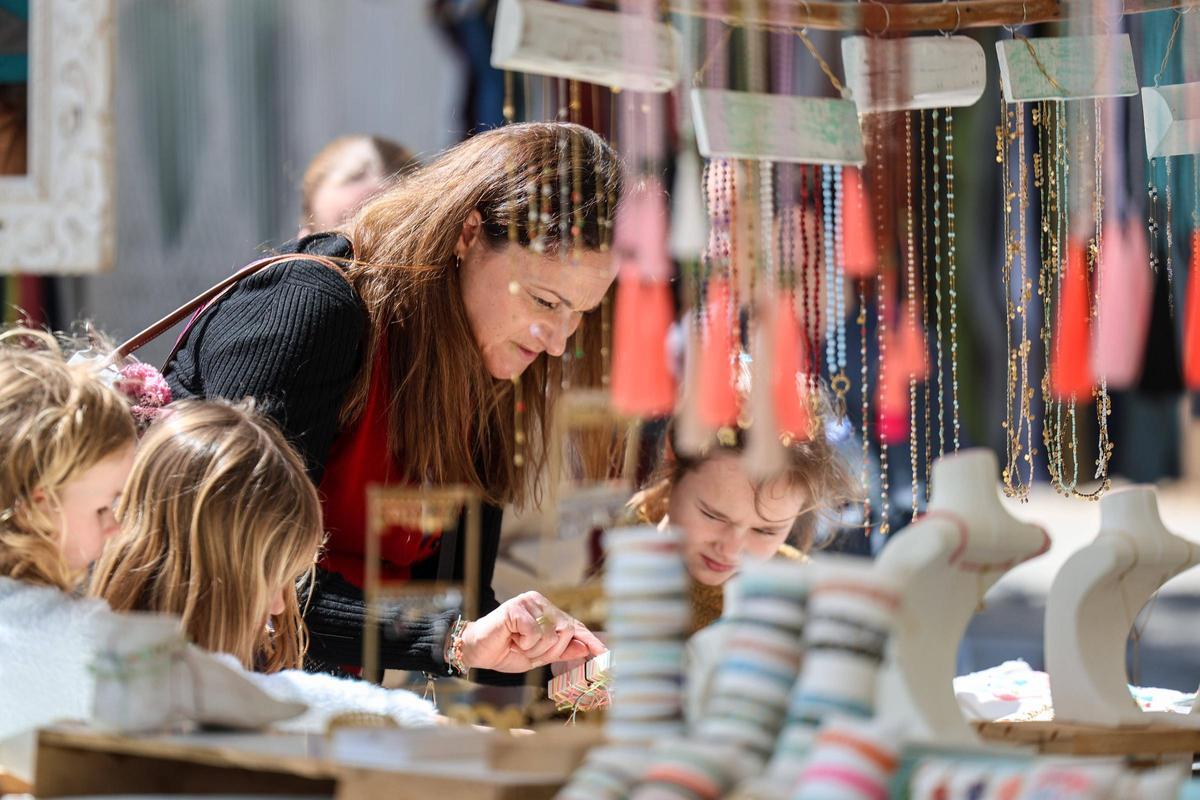 Una familia inspeccionando las pulseras de un estand.
