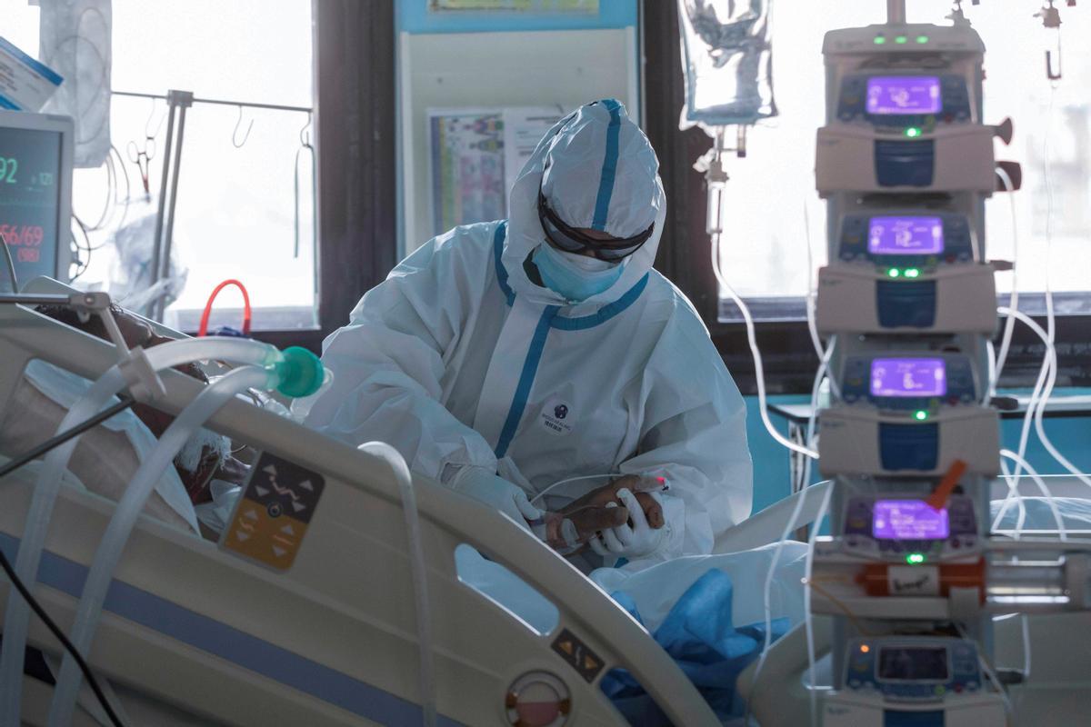 Un sanitario atiende a un paciente con covid en una UCI