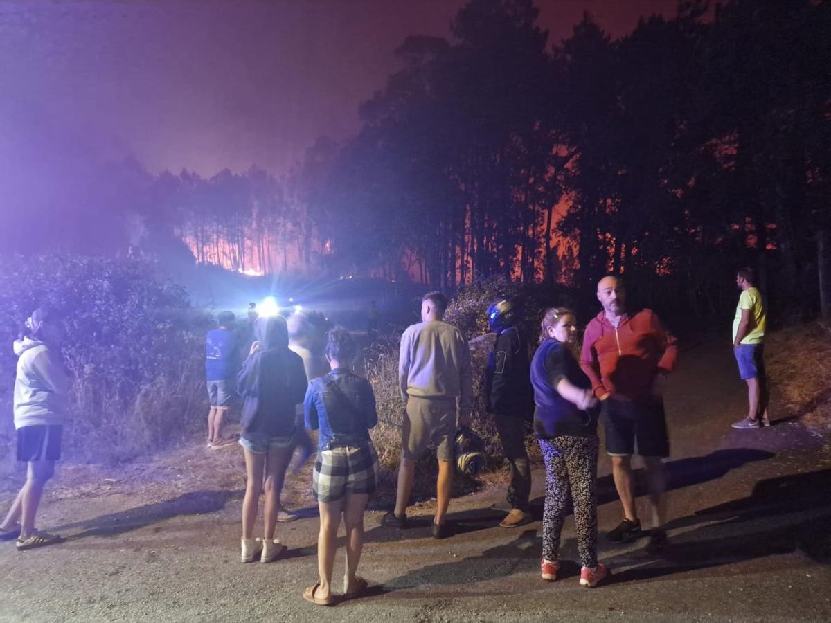 Vecinos de Castroagudín (Vilagarcía) observando el avance de las llamas, de madrugada.