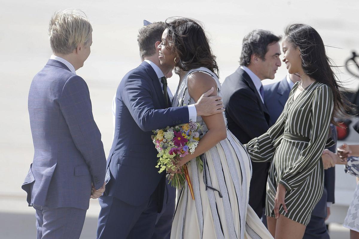 Michelle Obama saluda con los tradicionales dos besos al embajador James Costos y su marido