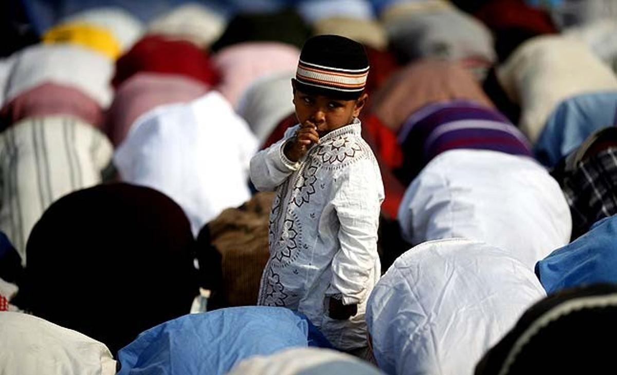 Un nen observa els devots que participen en les oracions del Bishwa Ijtema a Dhaka (Bangla Desh). El Bishwa Ijtema, que dura tres dies, és la segona congregació mundial on es reuneixen més musulmans després de la Meca.