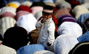 Un nen observa els devots que participen en les oracions del Bishwa Ijtema a Dhaka (Bangla Desh). El Bishwa Ijtema, que dura tres dies, és la segona congregació mundial on es reuneixen més musulmans després de la Meca.