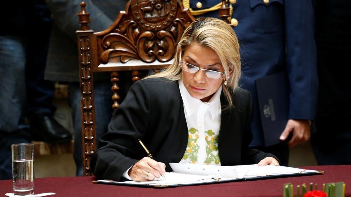 La presidenta interina de Bolivia, Jeanine Áñez, firma la ley para convocar nuevas elecciones en Bolivia, este domingo.