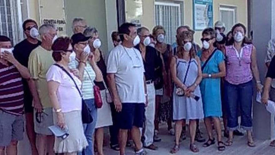 Los denunciantes con las mascarillas colocadas, en la puerta del centro de salud, ayer