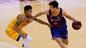 GRAF1550  BARCELONA  06 12 2020 - El escolta argentino del Barca Leonardo Bolmaro (d) avanza con el balon presionado por A  J  Slaughter  de Herbalife Gran Canaria  durante el partido de Liga ACB que se juega hoy domingo en el Palau Blaugrana  EFE Alejandro Garcia