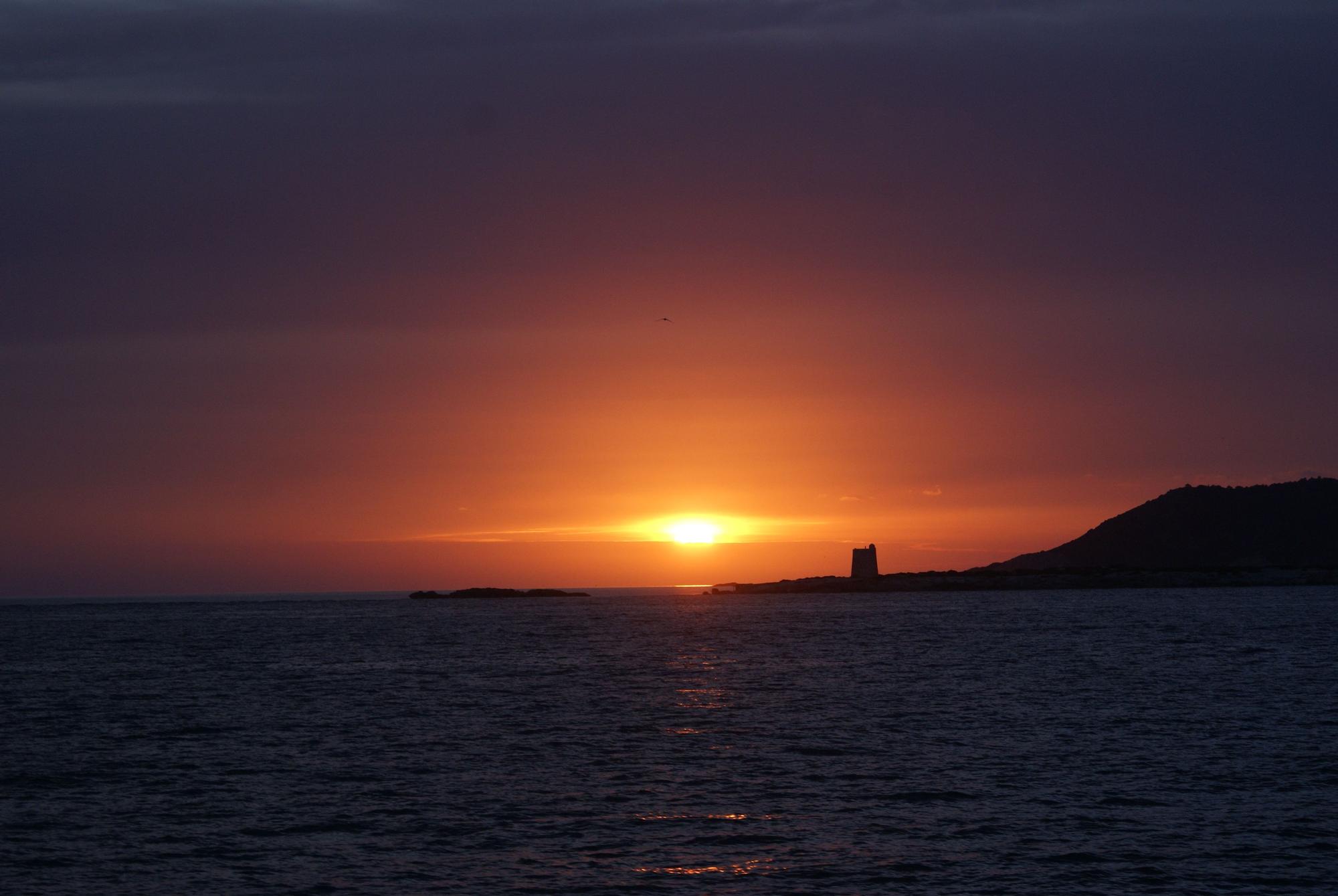 Puesta de sol con la Torre de ses Portes de fondo (Sant Josep).