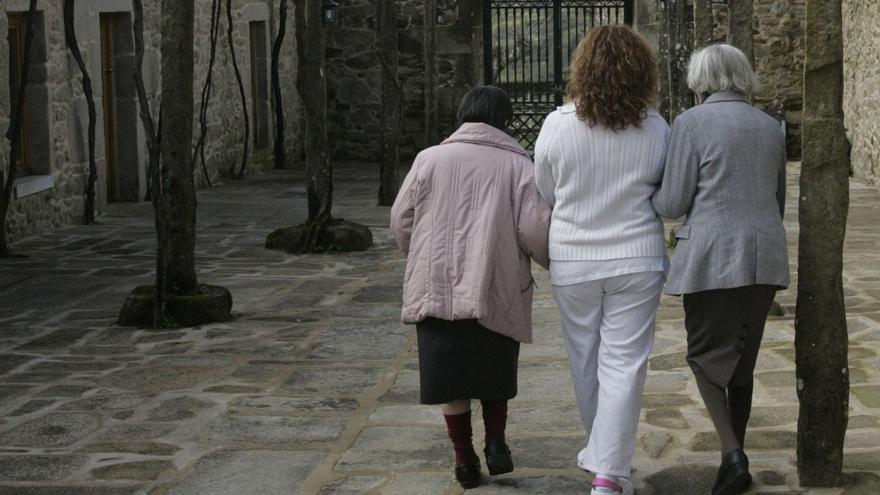 Dos ancianas son acompañadas por una trabajadora de un centro de Dodro. | Xoán Álvarez