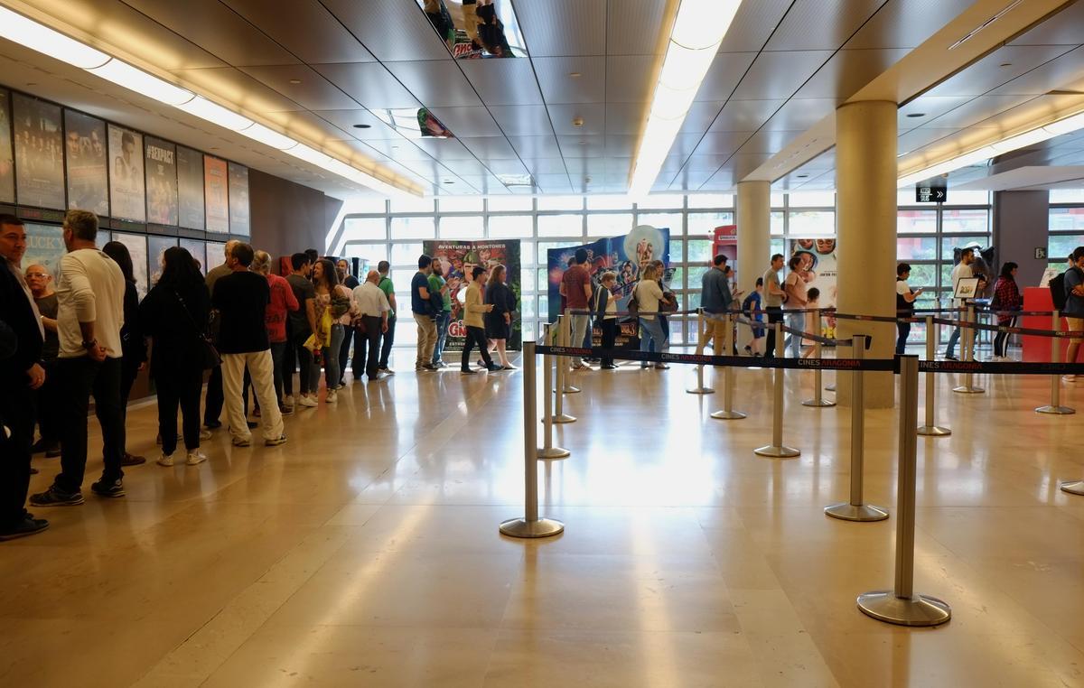 Espectadores haciendo cola para entrar al cine en Zaragoza.