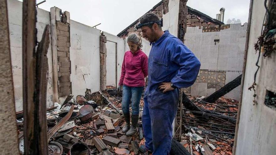 José Álvarez y Patricia Soalleiro, en el interior de su casa calcinada en Melón. // Brais Lorenzo