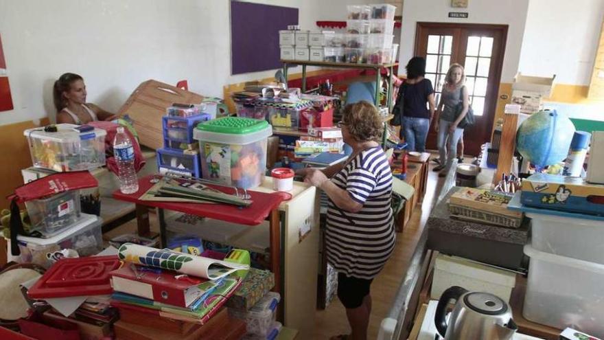 Familiares de alumnos de la escuela de Guillufe, ayer en el aula, todavía pendiente de pintar. // Adrián Irago