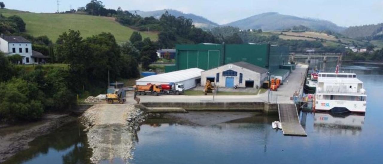 Maquinaria trabajando en la construcción de la rampa de botadura en el muelle sur de Castropol, que acoge la delegación de fibra del astillero (las naves verdes de grandes dimensiones). | Gondán