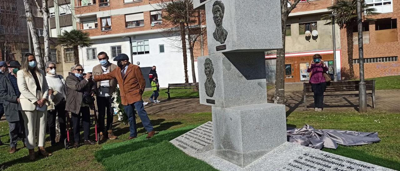 Rosario Sánchez y Juan de la Fuente chocan las manos a punto de realizar la ofrenda floral, con la consejera Rita Camblor, a la izquierda, y familiares de los homenajeados. | S. Arias