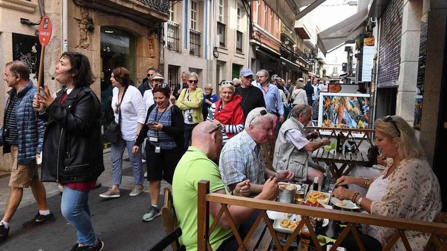 Turistas durante una visita guiada y en restaurantes en el centro de A Coruña.