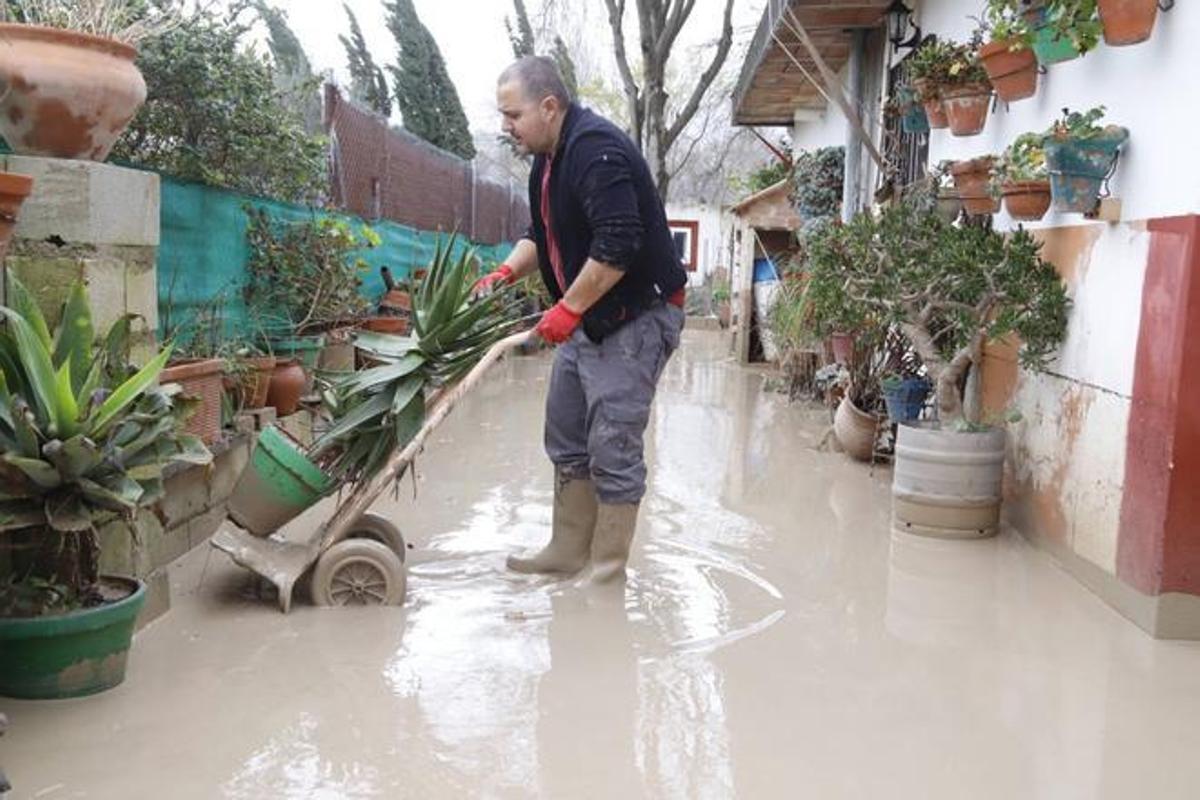 Un vecino de La Altea limpia su casa de lodo.