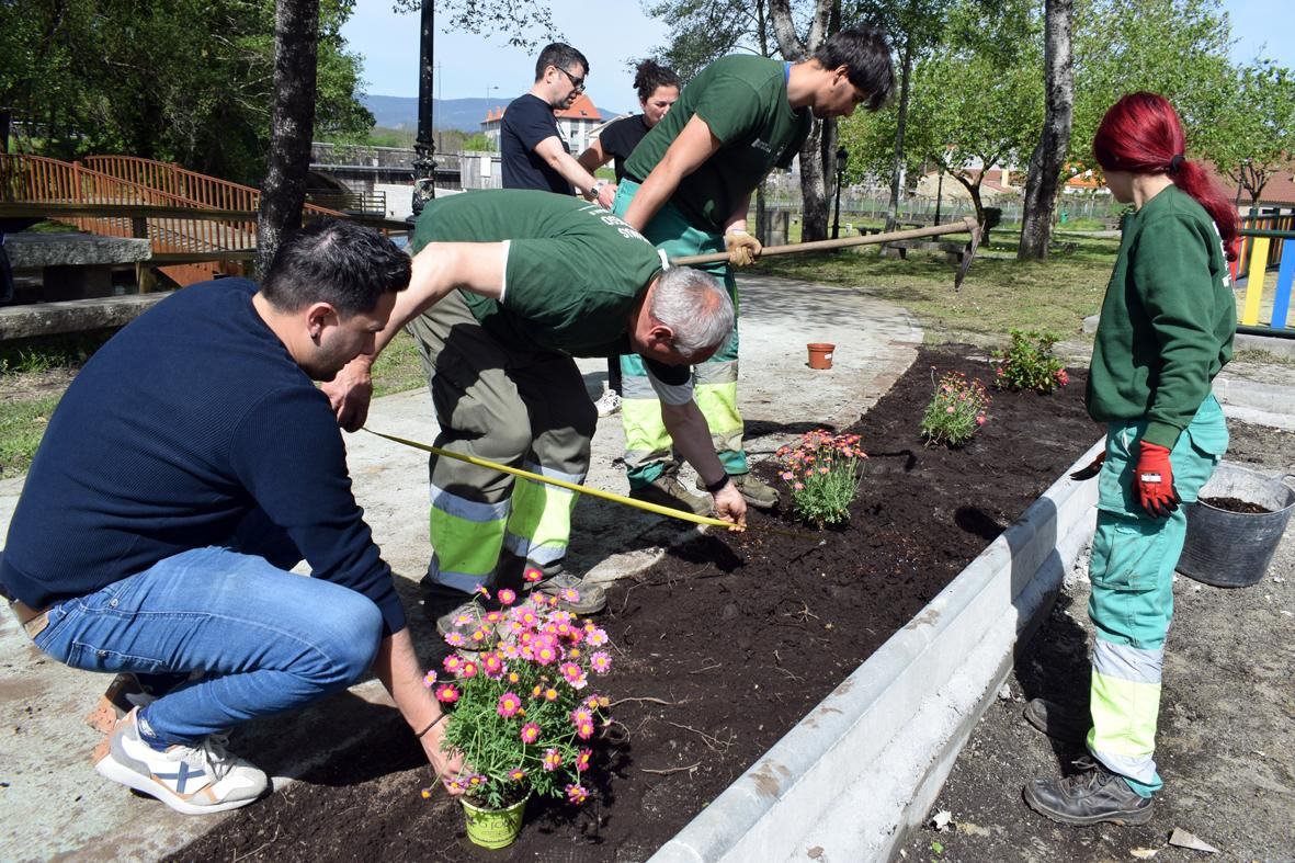 Alumnos del "Obradoiro de Emprego Xóvenes" durante la reforma y ajardinamiento del Parque Irmáns Dios Mosquera, en Valga.