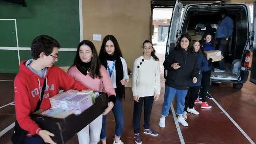 Un grupo de chavales carga una de las furgonetas.