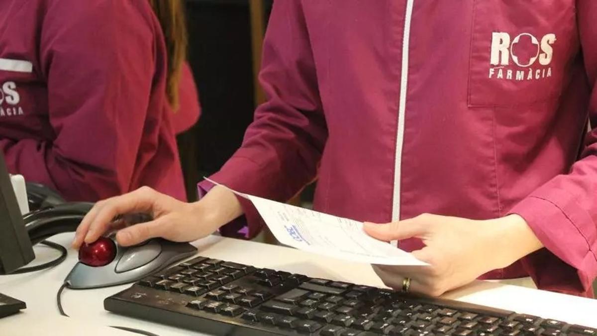 Una farmacéutica comprueba una receta médica.