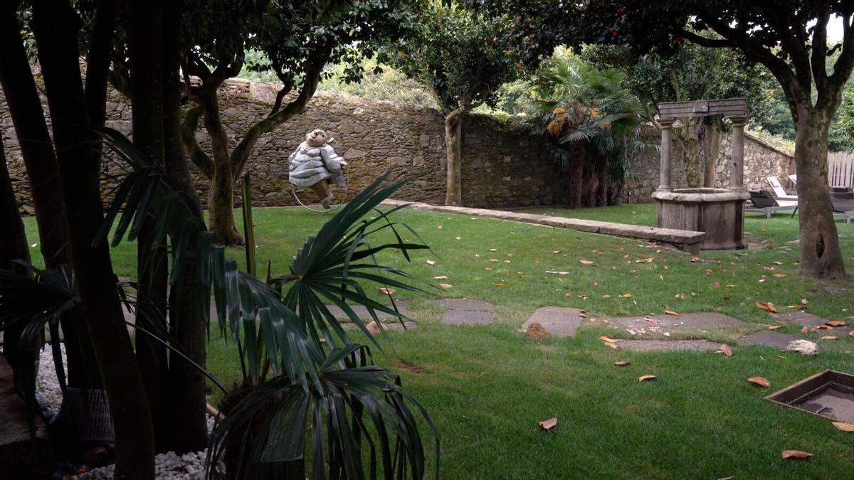 El jardín del Hotel Gaio 7, decorado con una estatua y un pozo de piedra.