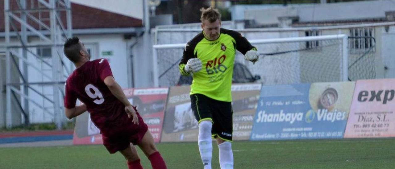 El meta caudalista Bussman despeja el balón con la cabeza en presencia del avilesino Cristian.