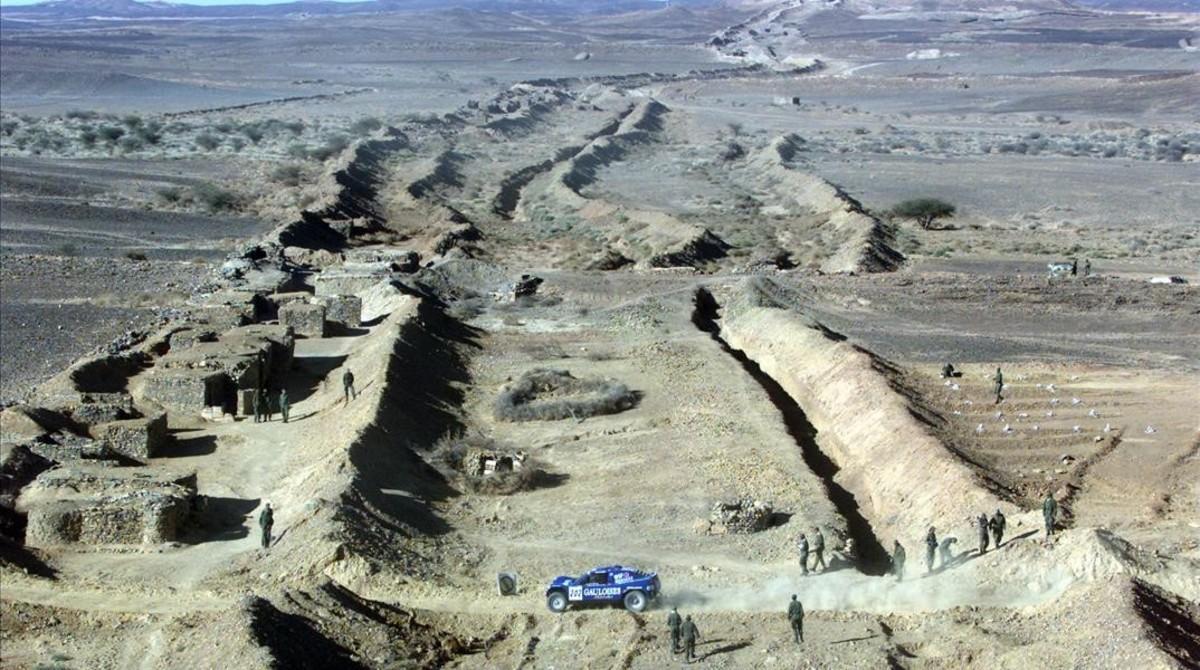 Un coche traspasa el muro de arena en la frontera entre Marruecos y Mauritania, en el Sáhara Occidental, en una etapa del rali París-Dakar, el 8 de enero del 2001.