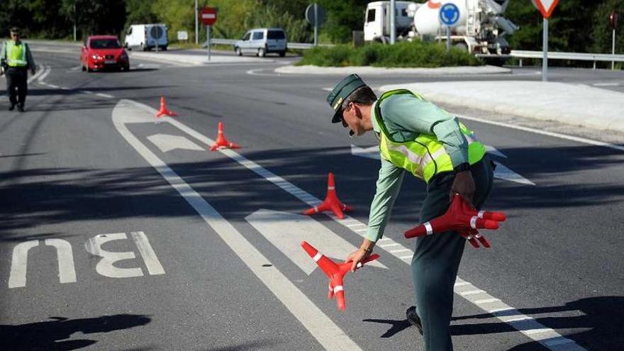 Un agente de la Guardia Civil instala unos conos para proceder a realizar un control en Pontevedra.