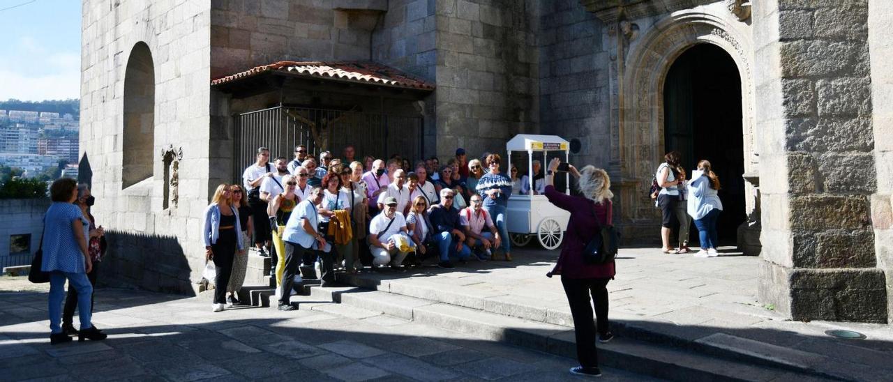 Un grupo de turistas se dejan fotografiar ante la basílica de Santa María de Pontevedra.  // GUSTAVO SANTOS