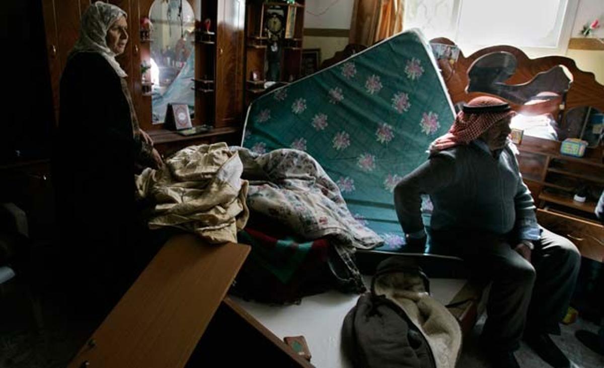 Dos palestins examinen els danys en les seves pertinences després de l’operació israeliana perpetrada al poble d’Awarta (Cisjordània) com a resposta a l’atac palestí en el pròxim assentament d’Itamar en el qual van morir assassinats cinc membres d’una família jueva mentre dormien.