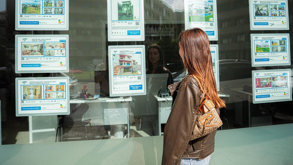 Una mujer observa el escaparate de una inmobiliaria en Vigo.