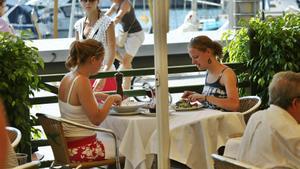 Dos comensales en un restaurante del Port Vell de Barcelona, el verano pasado.