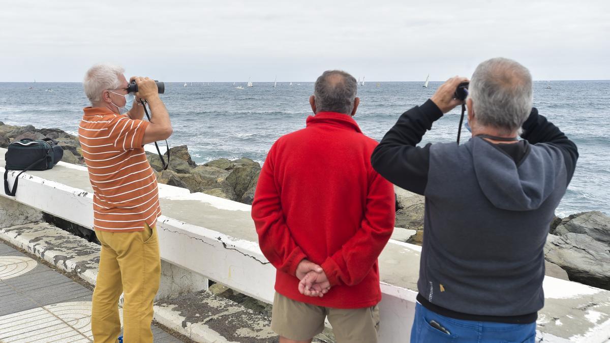 Varios aficionados de la vela latina observan desde la Avenida Marítima una regata