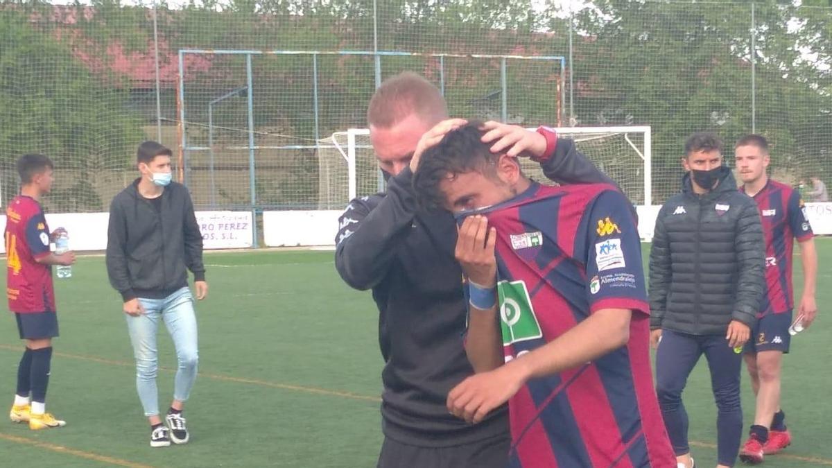 Ruiz, entrenador del Extremadura B, consuela a un jugador de su equipo.