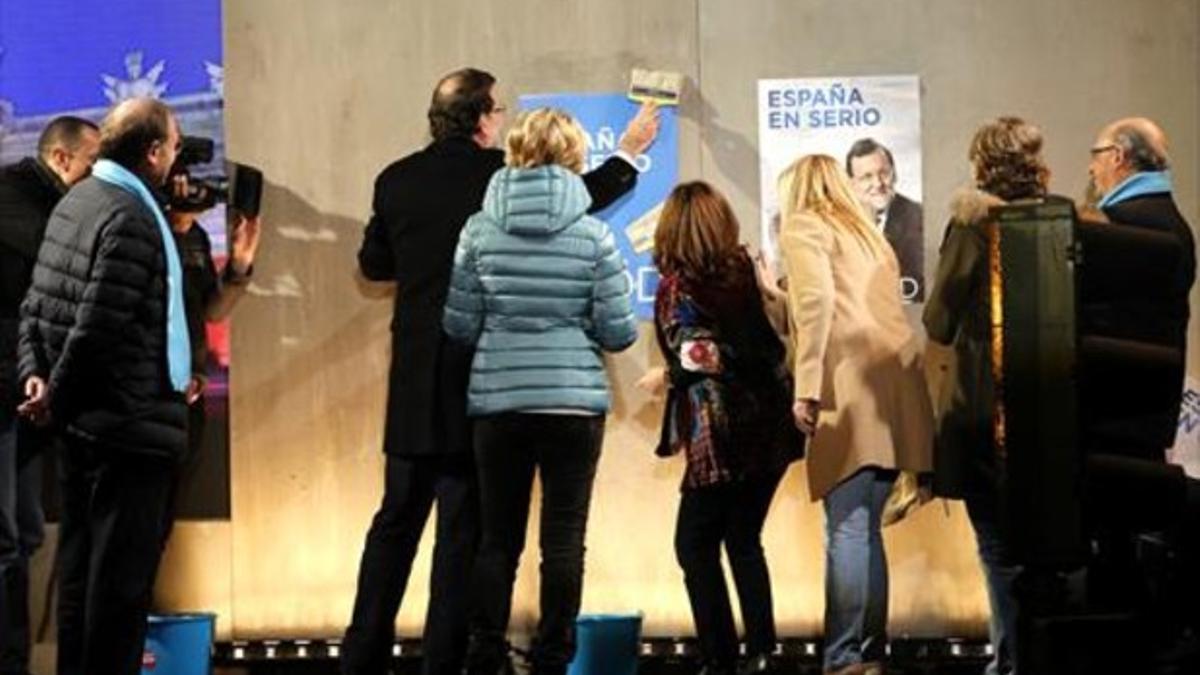 El presidente y candidato a la reelección del PP, Mariano Rajoy, en la tradicional pegada de carteles del arranque de campaña, en la sede central del partido, en Génova 13 (Madrid).