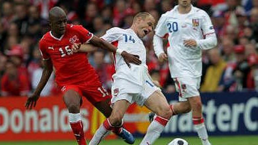 El jugador checo David Jarolim (c) pelea por el balón con el suizo Gelson Fernandes (i) durante el Suiza-República Checa, primer partido de la Eurocopa de fútbol 2008, correspondiente a la primera fase, grupo A, en el estadio &quot;St. Jakob-Park&quot; de Basilea, Suiza. A la derecha, el checo Jaroslav Plasil.