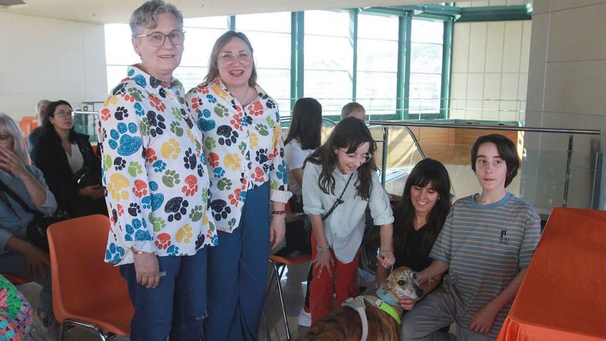 Luz Dacoba e Inés Quintián— secretaria y presidenta de la asociación— con una familia de socios.