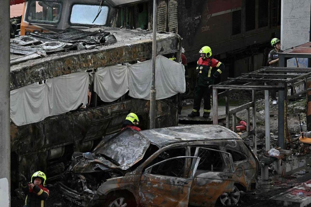 Imágenes del accidente entre un tren y un autobús en Bangkok, que ha dejado al menos ocho muertos y 25 heridos después de que el vehículo se incendiara tras el impacto.